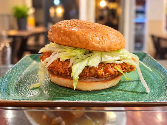 Hamburguesa de pollo crujiente con lechuga en pan de sésamo